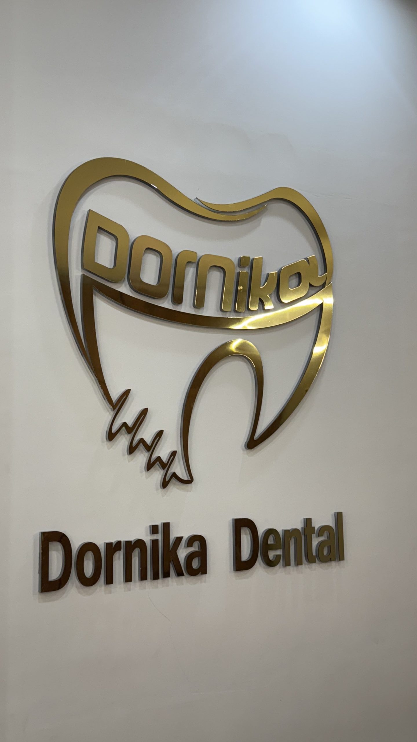 لوگوی طلایی دورنیکا روی دیوار کلینیک دندانپزشکی
